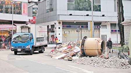 大量建築廢料被棄置於行車線，令途經車輛被迫越線而行。