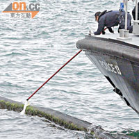 水警在隔油網內海面打撈證物。