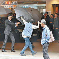 酒店保安人員打開雨傘遮擋郭老太的座駕。