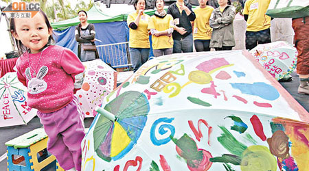 中產家庭合力以雨傘化為畫布繪出快樂希望，寓意家庭是遮風擋雨的地方。（陳德賢攝）