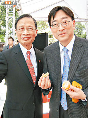 高永文（右）大讚胡劍江（左）送來嘅潮州蕉柑清甜又易剝皮。（余素月攝）