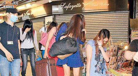 涉賣淫被捕內地女子連同行李被警方帶走。（馮戈攝）