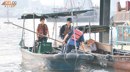 澳門港務局人員在北灣海面打撈死魚。