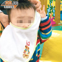 為免受油煙味影響，陳先生以口水肩為兒子遮掩口鼻。