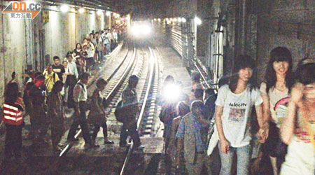近千名乘客摸黑沿路軌步行一百米往美孚月台。（梁國雄攝）