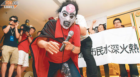 梁國雄打扮成的「港鐵吸血鬼」遭示威人士「叉頸」。（伍鎮業攝）