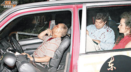 的士司機與兩名外籍男女乘客受傷坐於車內待援。（高偉明攝）