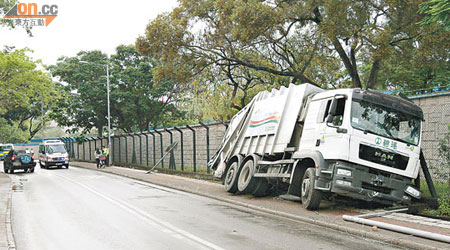 垃圾車與解放軍四驅車（左）相撞後衝上行人路復跌入水渠內。（胡德威攝）