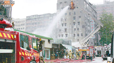 消防車升起雲梯向起火閣樓射水。 （左錦鴻攝）