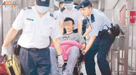 被捕疑犯由警員押送醫院治療。（蘇仲賢攝）