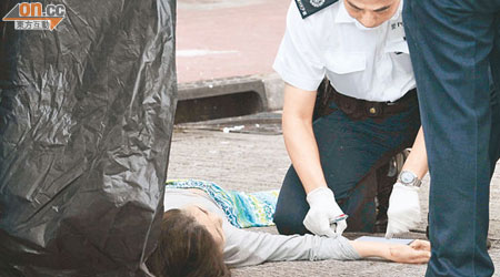 警員檢查墮斃女子屍體。（左蘭慶攝）