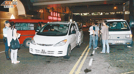 涉案七人車（中）被警方客貨車阻截，其中一輛客貨車（圖左）被狂撞。（麥少峰攝）