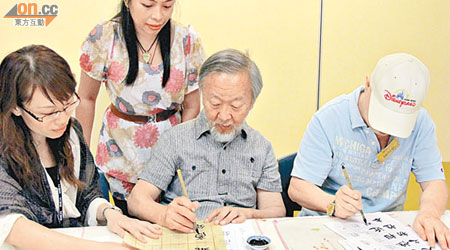 高錕（右二）喺卓智中心職業治療師陪同下練習寫毛筆字，訓練其專注力同手眼協調能力。（受訪者提供）