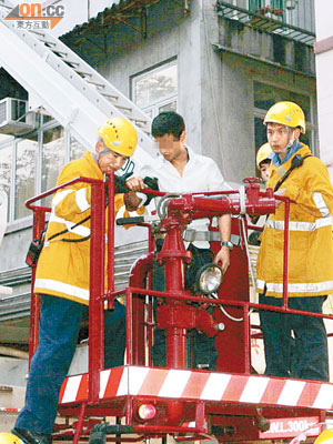 消防員用升降台將受傷爆竊疑犯送回地面。（劉展超攝）