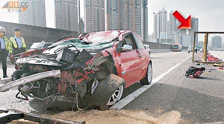 失事私家車遭工程路牌（箭嘴示）「壓頂」，車頭至車頂損毀嚴重。 （麥少峰攝）