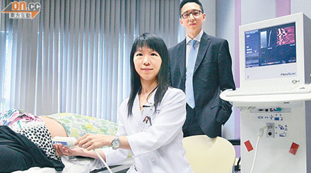 醫生黃麗虹及陳力元（右）示範用加大碼探頭深入較厚的皮下脂肪層，準確掃描肥胖病人的肝纖維化程度。（蘇文傑攝）