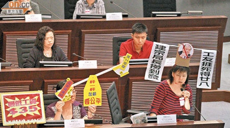 郭婉兒（前排右一）戴上寫有「建宗局長撈到發　工友捱死得廿八」紙帽，以示對工人不獲合理加薪的不滿。
