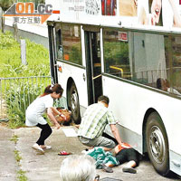 被捲入巴士的婦人，其丈夫及途人欲救無從。