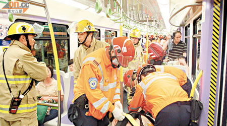 消防員在列車上拯救受傷乘客。（文健雄攝）