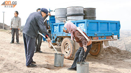 不少甘肅省山區居民需長途跋涉買水後再挑上山。（吳啟偉攝）