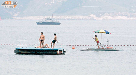 水警輪在赤柱海面搜索鯊蹤，泳客如常在泳灘游泳。（馬竟峯攝）