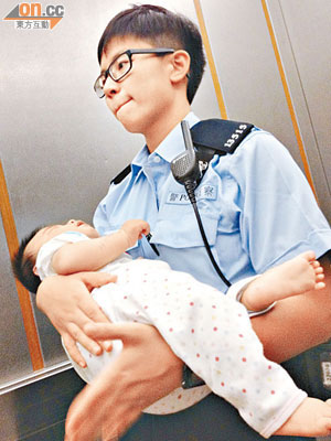 警員抱着男嬰送往醫院檢驗。（李子強攝）