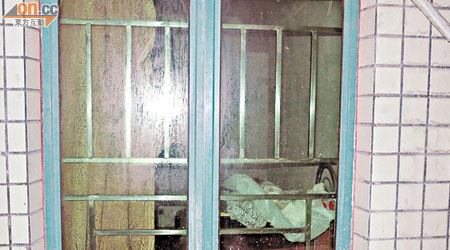 透過茶色玻璃窗可隱約見兇案單位廳中有梳化及床褥等傢俬。（本報深圳傳真）