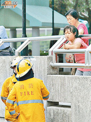 消防員向婦人與女童查問。（戴展邦攝）