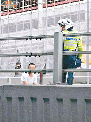 男子坐在天橋上，交通受阻，警員到場了解。（讀者提供）