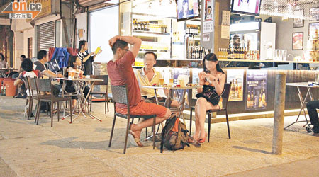 元朗福樂徑一間酒舖，客人坐在舖外的椅上飲啤酒。