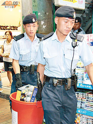 警員在元朗無牌酒吧檢走酒類飲品。（左蘭慶攝）