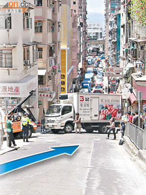 貨車在東邊街溜後衝行（箭嘴示），剷上行人路橫亘路中。（陳展鴻攝）