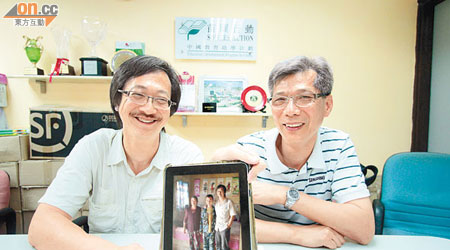 明威（左）和權叔展示到內地山區探訪的照片時，露出燦爛笑容。