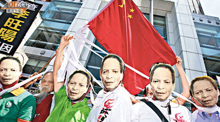 示威者戴上印有李旺陽遺照的面具，以白色布帶即場「自縊」。（黃仲民攝）