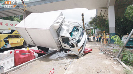 翻側凍櫃車由拖車吊起移正後拖走檢驗。（黃智康攝）