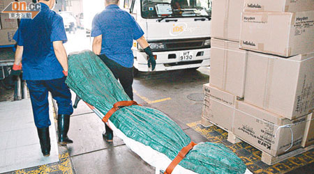 仵工將吊頸東主的遺體舁送殮房。（左錦鴻攝）