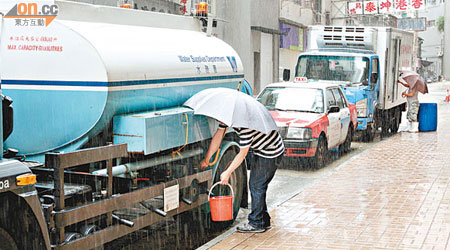 市民冒雨到水車取水應急。（陳展鴻攝）