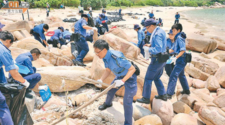 民安隊人員在南丫島深灣清理膠粒，上址為綠海龜產卵地方。