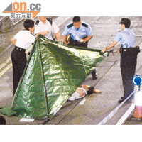 跳樓男子再遭的士輾過死亡，警員用帳篷蓋着屍體調查。（王譯揚攝）