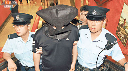 涉嫌偷拍少女裙底春的環保署督察被警員押走。（馮戈攝）