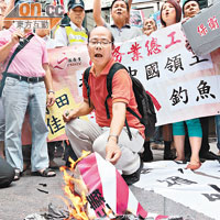 示威者在日駐港總領事館外焚燒日軍軍旗抗議。