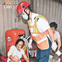 另一名女傷者身染鮮血，坐地接受治理。（邱國賢攝）