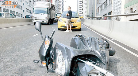 外籍男子將私家車停在肇事電單車後，以防女鐵騎士遭車輛輾過。（馬竟峯攝）
