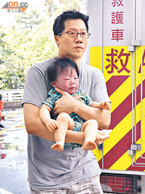 韓籍男嬰由父親抱送醫院治療。（郭錦良攝）