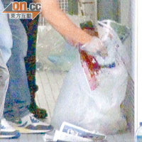 探員在大廈垃圾桶內檢獲染血報紙。（陳潔碧攝）