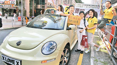 本港首位同志議員陳志全，昨日坐着「X LOVE X」車牌的跑車向選民謝票。（梁耀榮攝）
