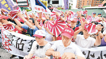 台灣的示威者在日本駐台交流協會外高呼抗議口號及撕毀日本軍旗。（中央社圖片）
