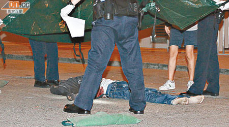 疑跳樓自殺男子倒臥馬路上，警員用帳篷覆蓋屍體及在場調查。（左蘭慶攝）
