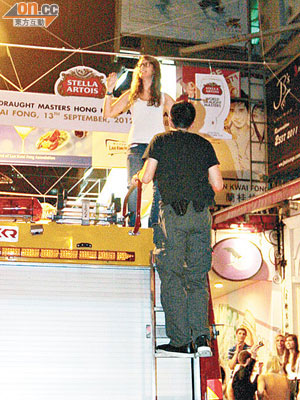 外籍女子爬上消防車車頂跳舞，便衣警員登上鋼梯勸喻。（呂浩鋒攝）