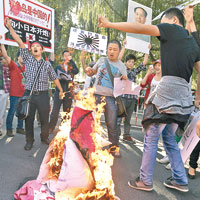 北京示威者日前在日本駐華大使館前焚燒日本旗洩憤。（資料圖片）